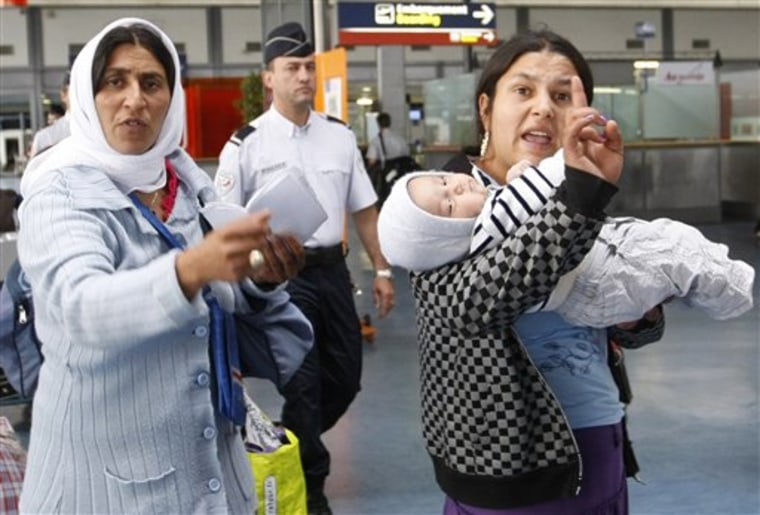 Roma women gesture before being expelled from France at Roissy airport, north of Paris, on Thursday. The Archbishop of Paris, Andre Vingt-Trois has added to mounting criticism of the French government's crackdown on Gypsies, or Roma, calling it a "circus." 